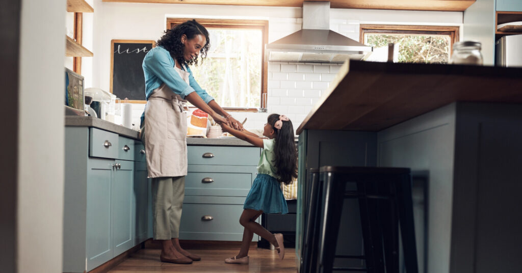Mother playing with daughter in kitchen