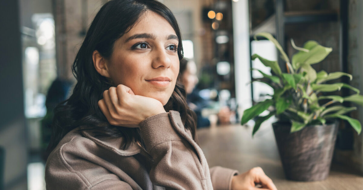 Young woman sitting in cafe and in deep thought