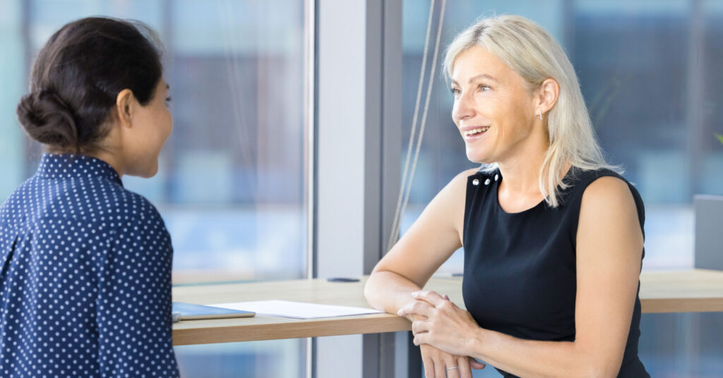 Older businesswoman talking to a younger businesswoman