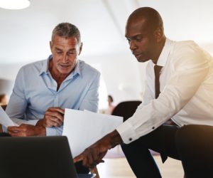 Two colleagues having a business discussion over paperwork