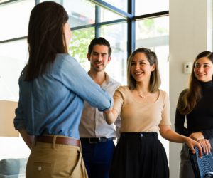 Colleagues shaking hands in front of team