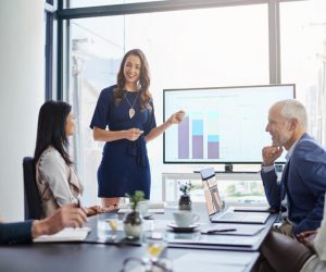 Businesswoman analysis giving a statistic presentation in a diverse boardroom.