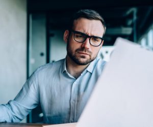 Business person looking at paper with concerned yet pensive look