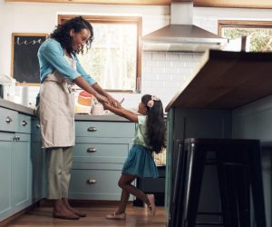 Mother playing with daughter in kitchen